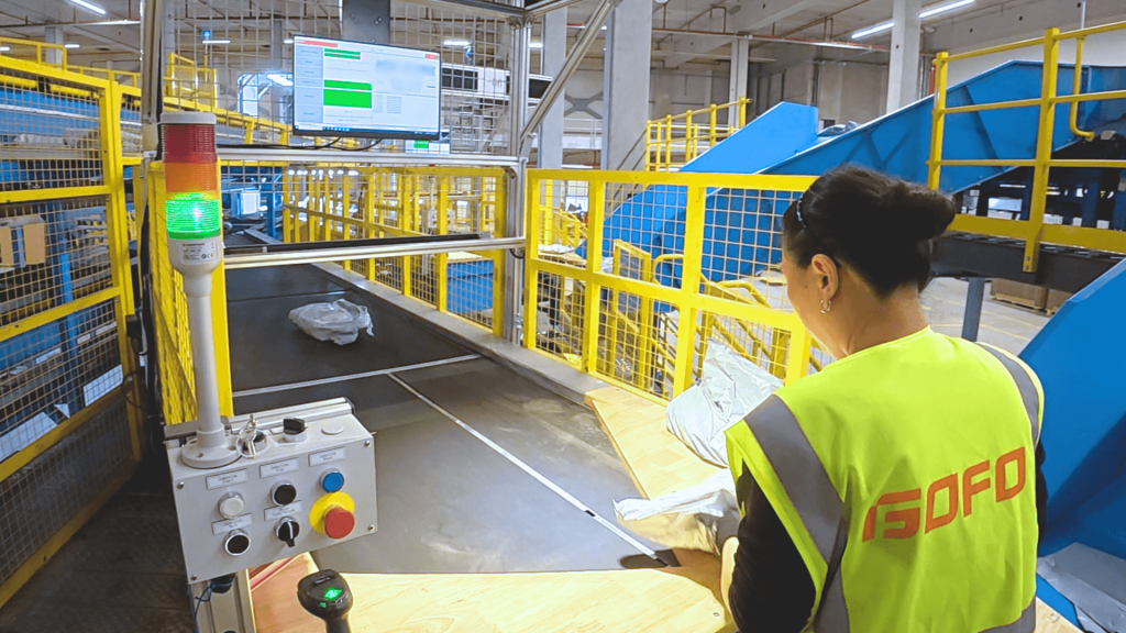 An Operational Specialist Handling Parcel on Double Cross-Belt Sorter in GOFO Sorting Hub in Amsterdam.